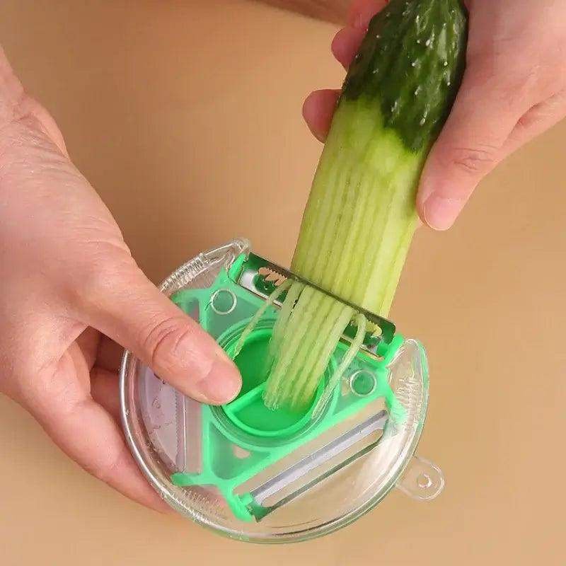Hands using a 3 in 1 stainless steel vegetable peeler to julienne a cucumber with a non-slip design.